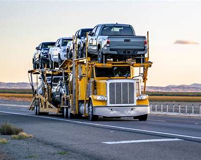 Car Transport Process showing a vehicle being loaded onto an open carrier during professional pickup.
