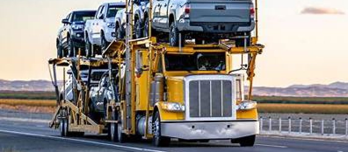 Car Transport Process showing a vehicle being loaded onto an open carrier during professional pickup.