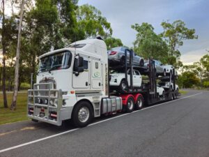 Luxury car in enclosed auto transport trailer with driver checking